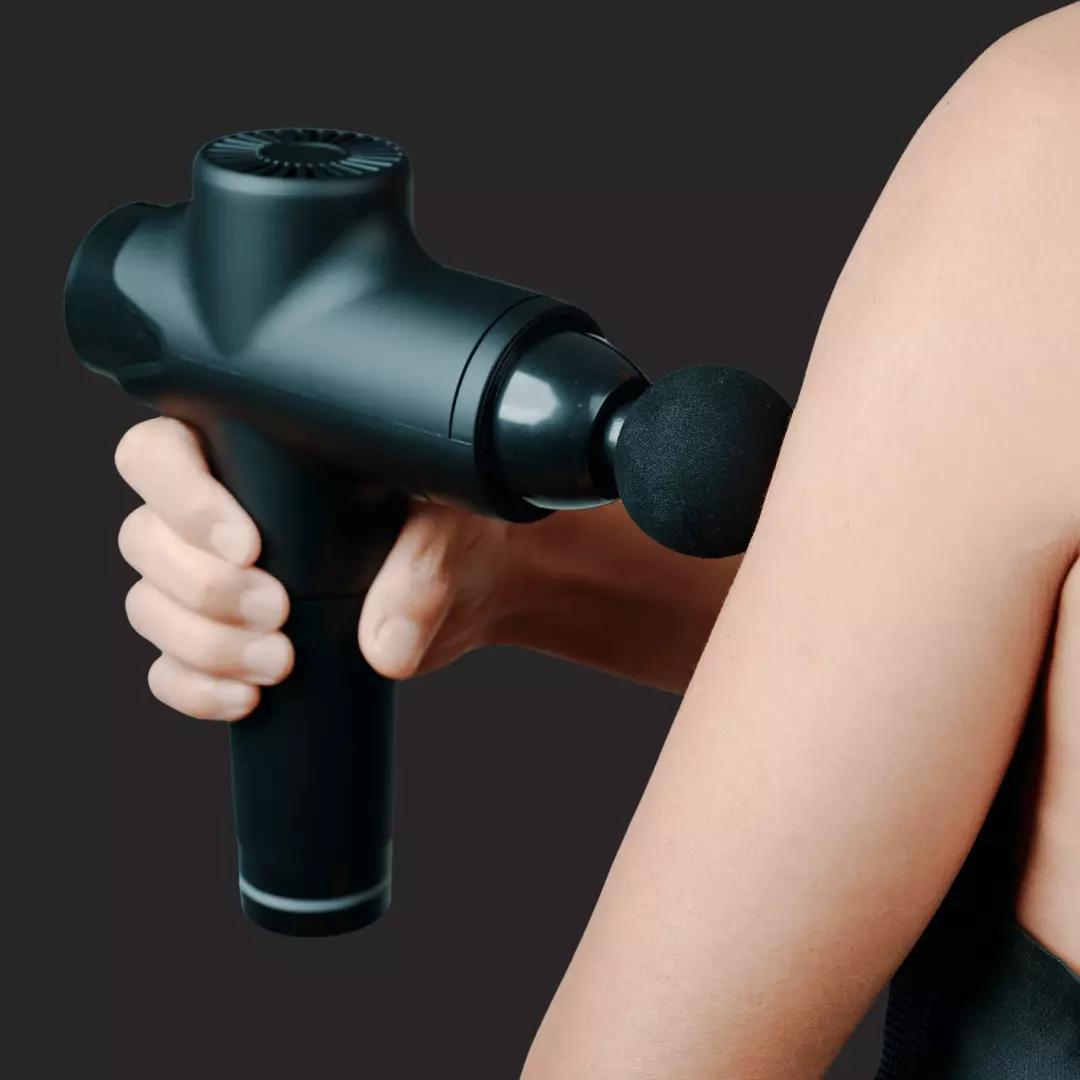 A massage gun hold by a person and doing a muscle massage.